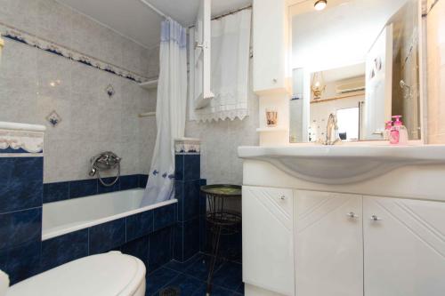 a bathroom with a white sink and a toilet at Cycladic Grandma's Apartments in Parikia