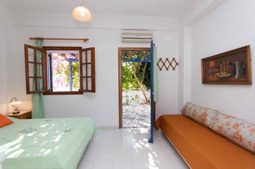 a bedroom with a bed and a door to a patio at Cycladic Grandma's Apartments in Parikia