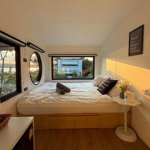 a bed in a small room with a window at เติมฝัน แคมป์ปิ้ง in Ban Ra-ok