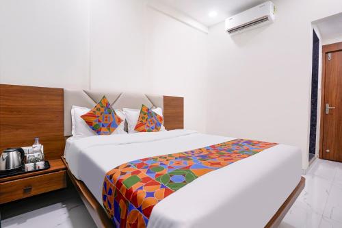 a bedroom with a large bed with a colorful blanket at FabHotel Vishwas in Aurangabad