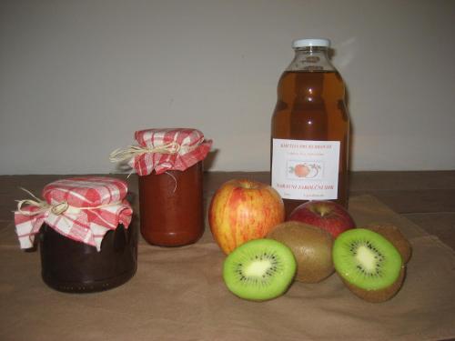 a bottle of apple cider next to apples and kiwis at Turistična kmetija Pri Rebkovih in Ajdovščina