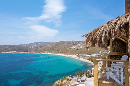 a view of a beach with a thatch roof at Greco Philia Hotel Boutique by Mr and Mrs White in Elia Beach