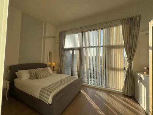a bedroom with a bed and a large window at Salt House, Stunning Swansea Marina Townhouse Sleeps 12, Beach & Arena in Swansea