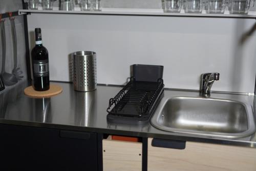 a kitchen counter with a sink and a bottle of wine at Farina Apartments in San Nicola La Strada