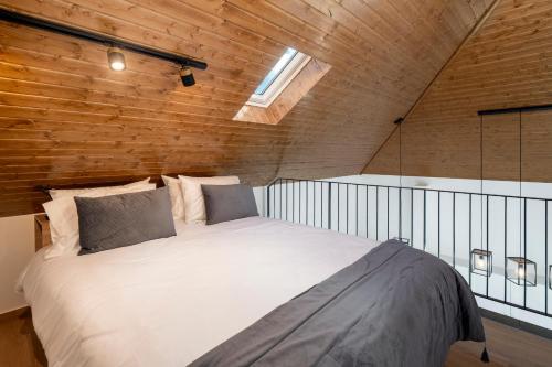 a large bed in a room with a wooden wall at Exceptional stone character house Chalet Prazeres in Prazeres