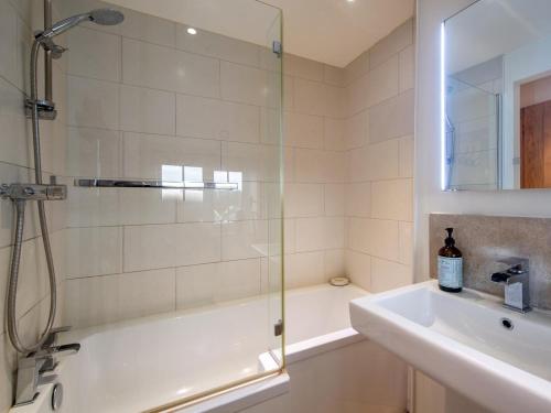 a bathroom with a shower and a tub and a sink at 3 Bed in Bridport oc-dc080 in Charmouth