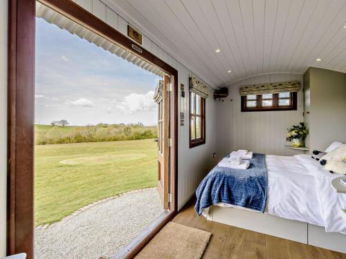a bedroom in a tiny house with a large window at 1 Bed in Beaworthy oc-77361 in Ashwater
