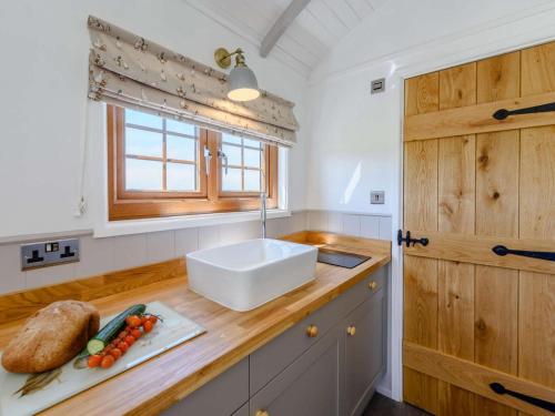 a kitchen with a sink and a wooden counter top at 1 Bed in Beaworthy oc-82834 in Ashwater