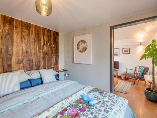 a bedroom with a bed with a wooden wall at 1 Bed in Okehampton oc-78087 in Hatherleigh