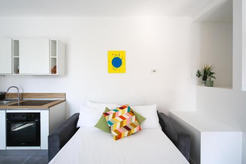 a white living room with a couch and a kitchen at KHL APARTMENTS - SanSiro, Milano in Milan