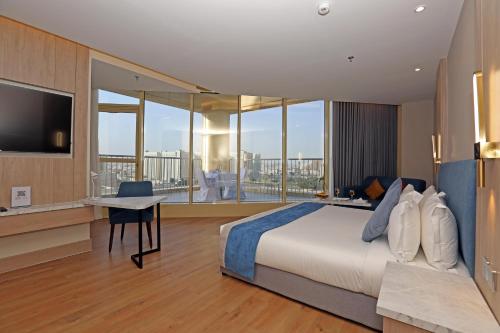 a bedroom with a bed and a desk with a television at Best Western Premier Riyadh in Riyadh