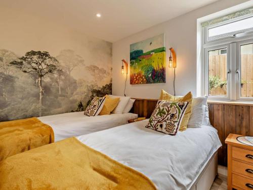 a bedroom with two beds and a painting on the wall at 2 Bed in Barnstaple oc-94038 in Bishops Tawton