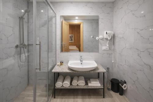 a white bathroom with a sink and a shower at Chateau Chao in Khulo