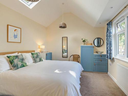 a bedroom with a white bed and a blue cabinet at 2 Bed in Taunton oc-96234 in West Quantoxhead