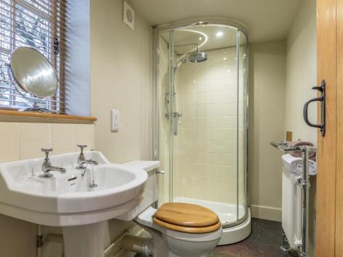 a bathroom with a sink and a toilet and a shower at 3 Bed in Axminster oc-bloco in Axminster