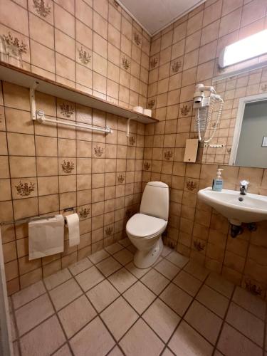 a bathroom with a toilet and a sink at Hotel Margrethe in Gadbjerg