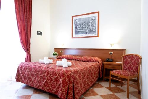 a hotel room with a bed and a chair at Hotel RomAntica in Rome
