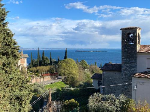 a view of the ocean from a building with a clock tower at Seeblick VILLA LAGUNA BLUE - Private Spa - Whirlpool & Sauna in Gardone Riviera