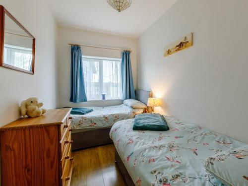 a bedroom with two beds and a dresser and a window at 2 Bed in Ottery St Mary oc-lambs in Ottery Saint Mary