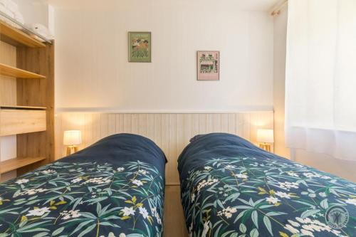 a bedroom with a bed with a blue blanket at Gîte G1304 in Sottevast
