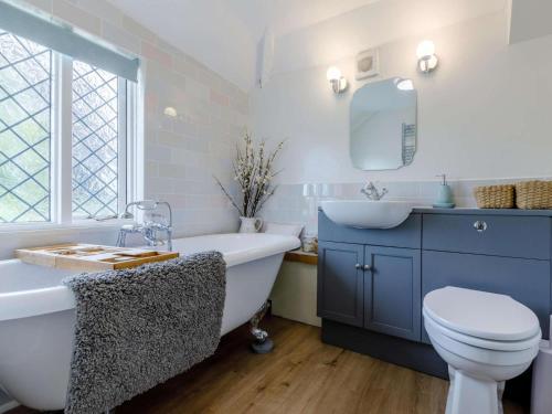 a bathroom with a tub and a toilet and a sink at 1 Bed in Chulmleigh oc-82389 in Chulmleigh