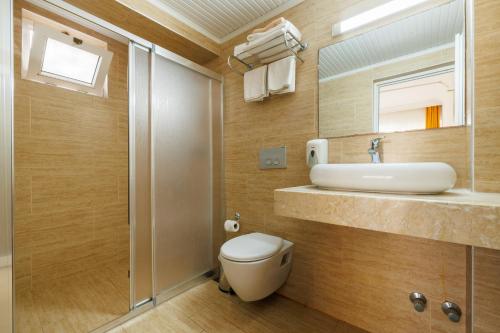 a bathroom with a toilet and a sink and a shower at Ten Apart Hotel in Fethiye