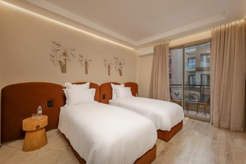 a hotel room with two beds and a window at GUELIZ Seven Stays in Marrakesh
