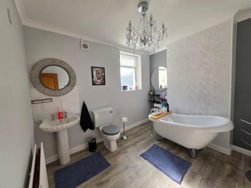 a bathroom with a tub and a toilet and a sink at Ample town house in Workington, West Lakes, Lake District in Workington