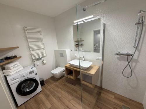 a bathroom with a washing machine and a washer at Apartamenty Leśna 1 in Zielona Góra