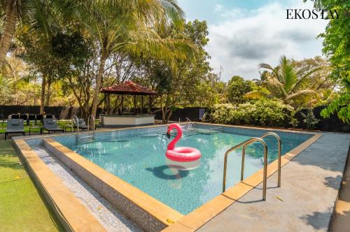 a swimming pool with a swan in the middle at EKOSTAY Gold - Amara Villa in Alibaug