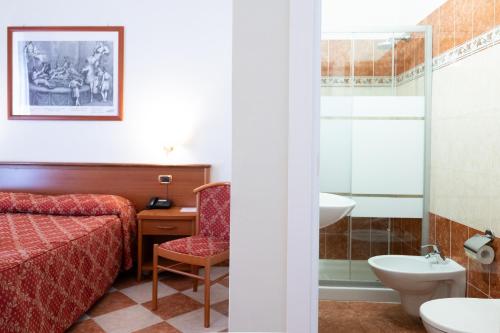 a hotel room with a bed and a bathroom at Hotel RomAntica in Rome