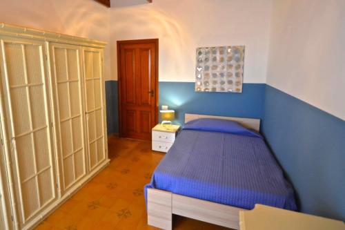 a bedroom with a bed and a blue wall at Villa La Timpa - antica e maestosa villa con jacuzzi privata con una meravigliosa vista sull'Etna e sul mare in Acireale