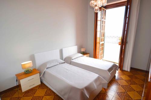 a bedroom with two beds and a chandelier at Villa La Timpa - antica e maestosa villa con jacuzzi privata con una meravigliosa vista sull'Etna e sul mare in Acireale