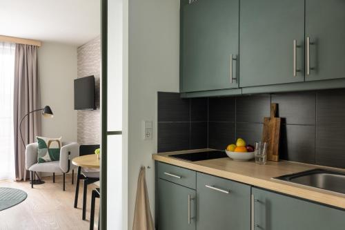 a kitchen with blue cabinets and a sink and a table at Bob W Munich City Centre in Munich