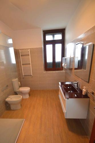 a bathroom with a toilet and a sink and a toilet istg at Villa La Timpa - antica e maestosa villa con jacuzzi privata con una meravigliosa vista sull'Etna e sul mare in Acireale