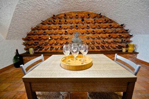 a table with wine glasses on it with a wall of wine bottles at Villa La Timpa - antica e maestosa villa con jacuzzi privata con una meravigliosa vista sull'Etna e sul mare in Acireale