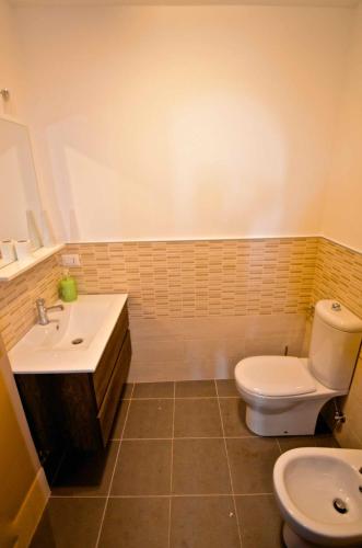 a bathroom with a toilet and a sink at Villa La Timpa - antica e maestosa villa con jacuzzi privata con una meravigliosa vista sull'Etna e sul mare in Acireale