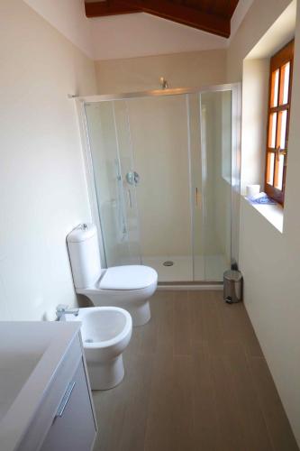 a bathroom with a toilet and a glass shower at Villa La Timpa - antica e maestosa villa con jacuzzi privata con una meravigliosa vista sull'Etna e sul mare in Acireale