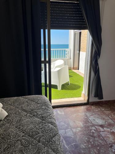 a bedroom with a bed and a view of the ocean at A la Orilla del Mar in Matalascañas