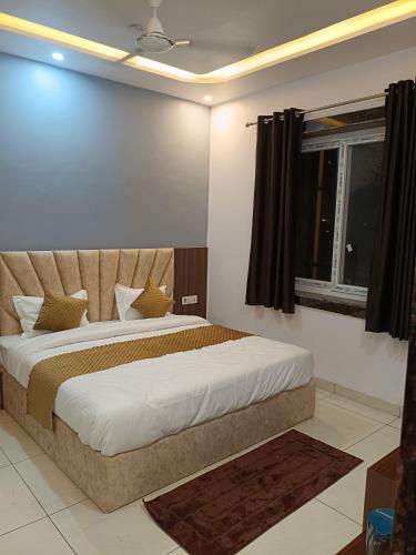a bedroom with a large bed and a window at Dev Hotel & Restaurant in Vrindāvan