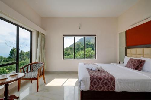 a bedroom with a bed and a table and a window at Cloud Dale Resort Munnar in Munnar