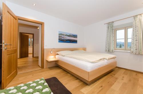 a bedroom with a bed and a large window at Ferienwohnungen Flattnerhof in Mauterndorf
