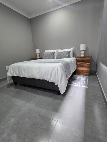a bedroom with a large bed and two night stands at The Oak GuestUnit in Kathu