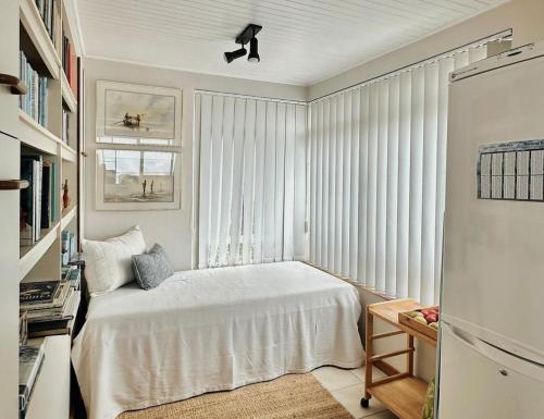 a bedroom with a white bed and a window at Nice Sea View in Plettenberg Bay