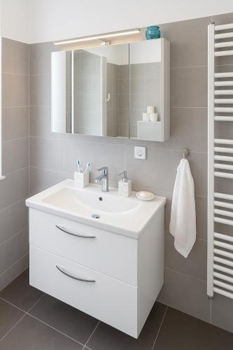 a bathroom with a white sink and a mirror at Deluxe Apartments Zagreb in Zagreb