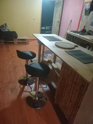 a wooden table with two stools in a room at Refugio del Pirata Algarrobo in San Antonio