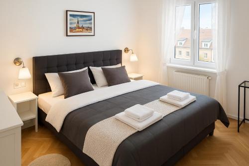 a bedroom with a large bed with two towels on it at Deluxe Apartments Zagreb in Zagreb