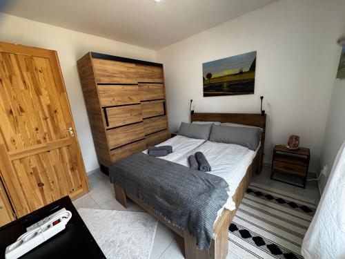 a bedroom with a large bed and a wooden door at Somló Home in Somlószőlős