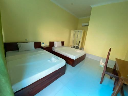 a bedroom with two beds and a desk and a sink at Pov Monique 2 in Stœ̆ng Trêng