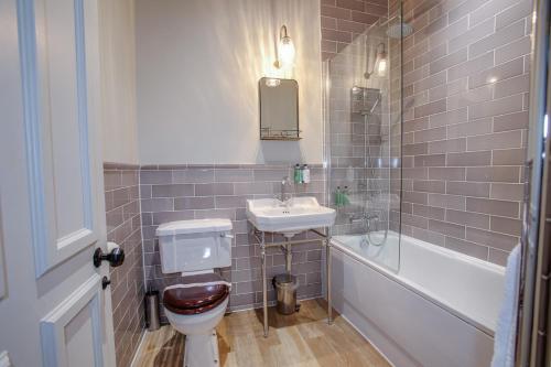 a bathroom with a toilet and a sink and a tub at The Black Hat in Ilkley